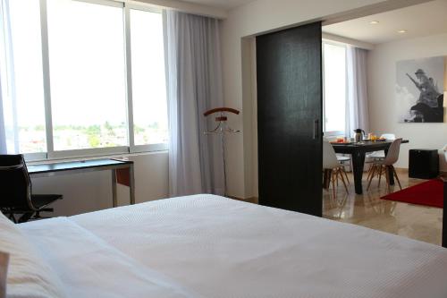 a bedroom with a bed and a desk and a table at Fiesta Inn Monterrey la Fe in Monterrey