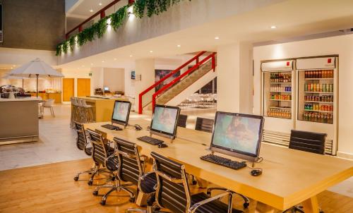 a long table with three computers on top of it at Fiesta Inn Tlalnepantla in Mexico City