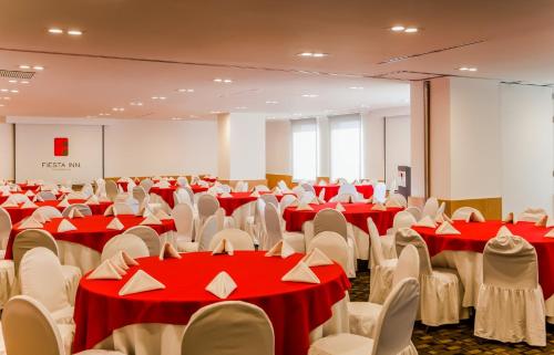 a conference room with red and white tables and chairs at Fiesta Inn Tlalnepantla in Mexico City