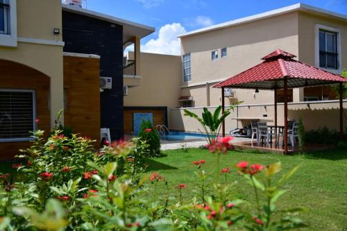 a yard with a patio with an umbrella and flowers at Ananda stays in Debāri