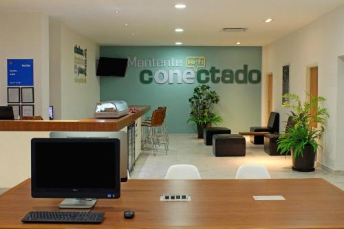 a computer monitor sitting on a desk in a lobby at One Acapulco Diamante in Acapulco