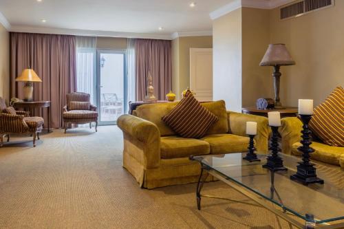 a living room with a couch and a glass table at Gamma Monterrey Gran Hotel Ancira in Monterrey