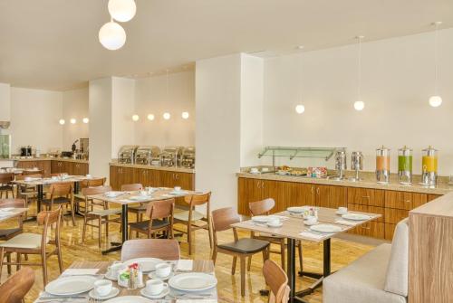 a restaurant with tables and chairs and a counter at Fiesta Inn Guadalajara Periferico Poniente in Guadalajara