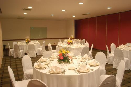 a banquet hall with white tables and chairs with white table cloth at Fiesta Inn Ciudad de México Aeropuerto in Mexico City