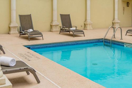 a swimming pool in a hotel with chairs and a swimming pool at Gamma Monterrey Gran Hotel Ancira in Monterrey