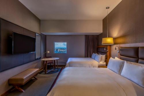 a hotel room with two beds and a flat screen tv at Fiesta Americana San Luis Potosi in San Luis Potosí