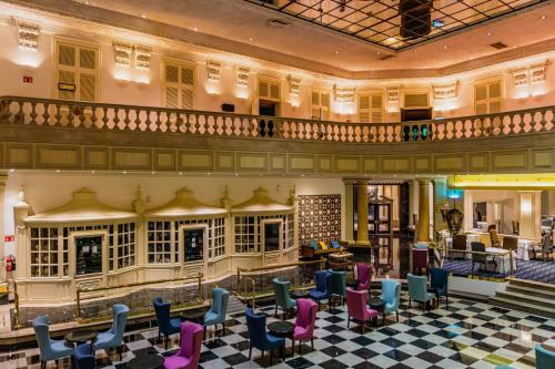 a lobby of a hotel with chairs and tables at Gamma Monterrey Gran Hotel Ancira in Monterrey
