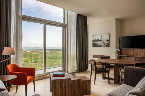 a living room with a table and a large window at Fiesta Inn Cancun Las Americas in Cancún