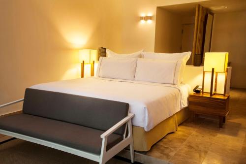 a bedroom with a large bed and a chair at The Explorean Cozumel All Inclusive in Cozumel