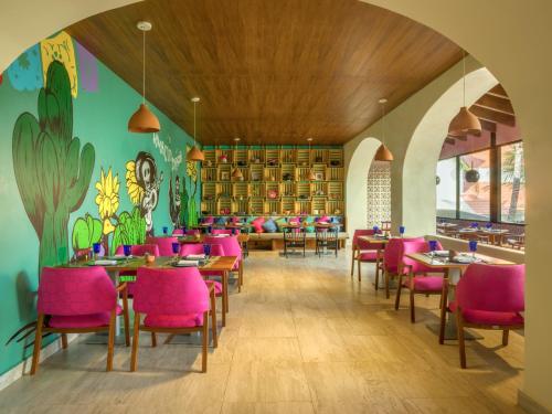 a dining room with pink chairs and tables at Fiesta Americana Condesa Cancun - All Inclusive in Cancún