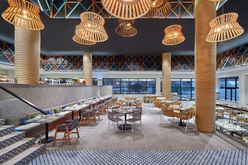 a restaurant with tables and chairs and chandeliers at Fiesta Americana Condesa Cancun - All Inclusive in Cancún