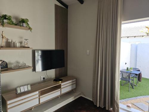a living room with a flat screen tv on the wall at Lanina Garden Unit in Johannesburg
