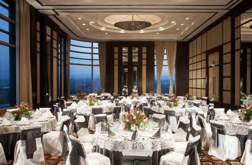 a banquet hall with white tables and chairs and windows at Grand Fiesta Americana Chapultepec in Mexico City