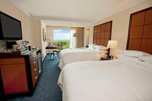 a hotel room with two beds and a flat screen tv at Grand Fiesta Americana Chapultepec in Mexico City
