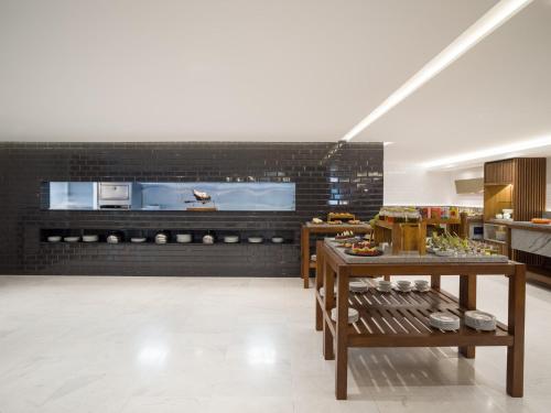a kitchen with wooden tables and a black brick wall at Grand Fiesta Americana Chapultepec in Mexico City