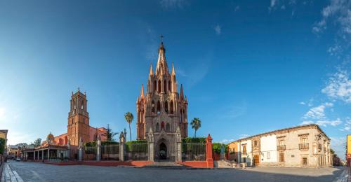 an old building with a tower in a city at Live Aqua San Miguel de Allende in San Miguel de Allende
