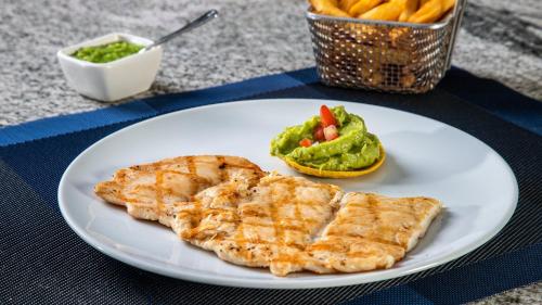 a white plate with a piece of fish and a bowl of fries at Grand Fiesta Americana Chapultepec in Mexico City