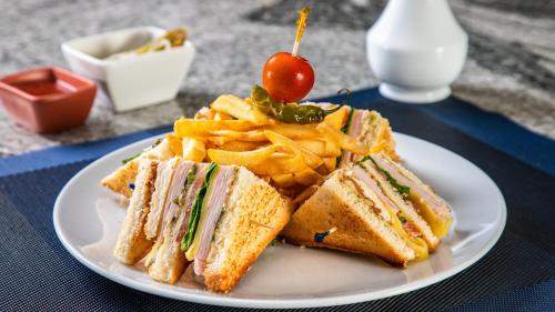 a white plate with a sandwich and french fries at Grand Fiesta Americana Chapultepec in Mexico City