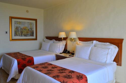 a hotel room with two beds with white sheets at Fiesta Americana Puerto Vallarta All Inclusive & Spa in Puerto Vallarta