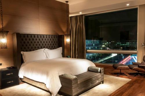 a bedroom with a large bed and a large window at Live Aqua Ciudad de Mexico Bosques de las Lomas in Mexico City