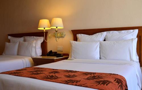 a hotel room with two beds with white pillows at Fiesta Americana Puerto Vallarta All Inclusive & Spa in Puerto Vallarta