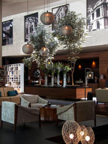 a lobby with couches and tables in a building at Live Aqua Ciudad de Mexico Bosques de las Lomas in Mexico City