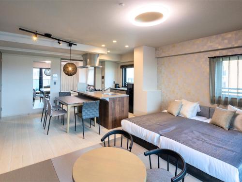 a living room with a bed and a dining room at The Riverfront Residence Nishihiroshima in Hiroshima