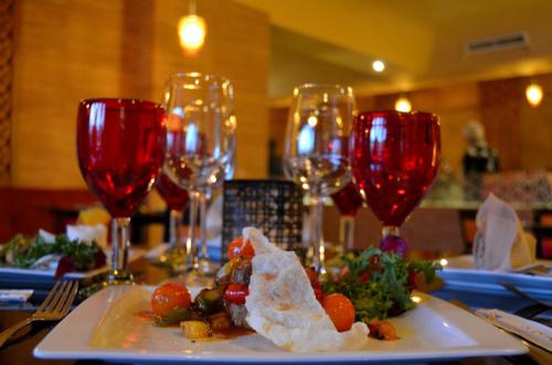 a plate of food on a table with wine glasses at Fiesta Americana Puerto Vallarta All Inclusive & Spa in Puerto Vallarta