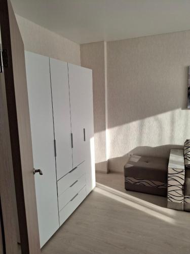 - une chambre avec un lit et une grande armoire blanche dans l'établissement Апартаменты на Седьмом Небесне, à Odessa