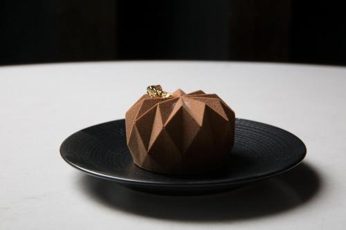 a chocolate dessert in a black hat on a table at Live Aqua Ciudad de Mexico Bosques de las Lomas in Mexico City