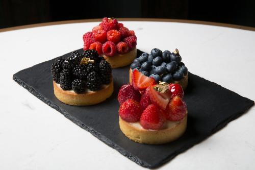 three donuts with fruit on a black plate at Live Aqua Ciudad de Mexico Bosques de las Lomas in Mexico City
