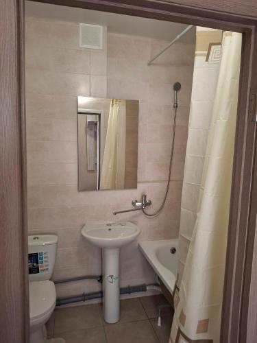 une salle de bain avec un lavabo, des toilettes et un miroir dans l'établissement Апартаменты на Седьмом Небесне, à Odessa