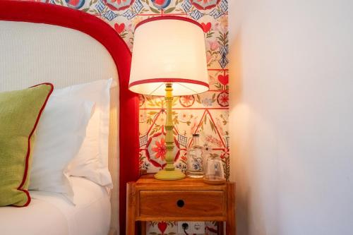 a lamp on a night stand next to a bed at Pergola Boutique Hotel in Cascais