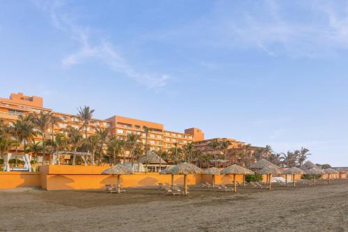 a resort with chairs and umbrellas on a beach at Grand Fiesta Americana Veracruz in Veracruz