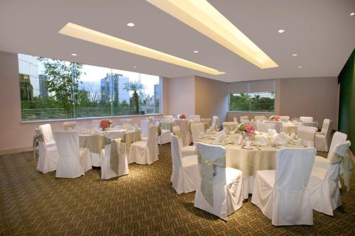 a banquet room with white tables and white chairs at Grand Fiesta Americana Guadalajara Country Club in Guadalajara