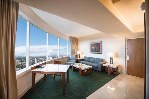 a living room with a couch and a large window at Grand Fiesta Americana Guadalajara Country Club in Guadalajara