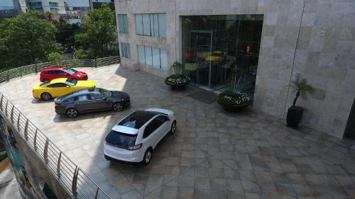 two cars parked in front of a building at Grand Fiesta Americana Guadalajara Country Club in Guadalajara