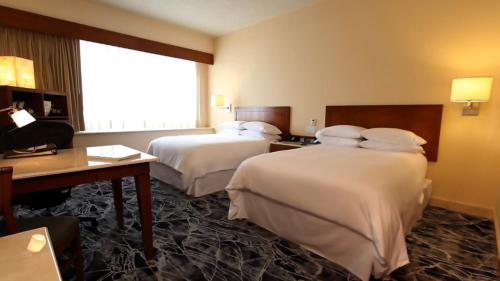 a hotel room with two beds and a window at Grand Fiesta Americana Guadalajara Country Club in Guadalajara