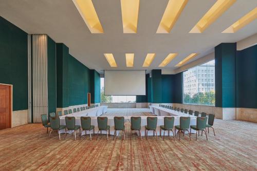 a conference room with chairs and a projection screen at Grand Fiesta Americana Guadalajara Country Club in Guadalajara