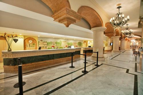 a hotel lobby with a bar in the middle at Fiesta Americana Merida in Mérida