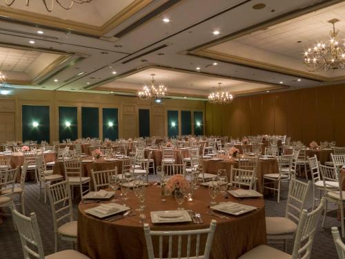 a banquet hall with tables and chairs and chandeliers at Fiesta Americana Merida in Mérida