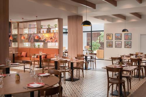 a restaurant with wooden tables and chairs and windows at Live Aqua Punta Cana - All Inclusive - Adults Only in Punta Cana