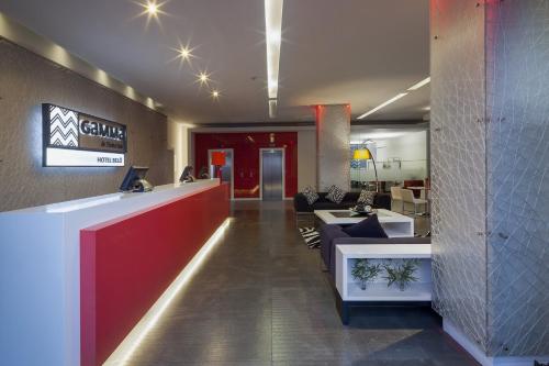 a lobby of a restaurant with a red and white counter at Gamma Morelia Belo in Morelia