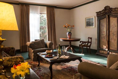 a living room with a coffee table and chairs at Fiesta Americana Hacienda Galindo Resort & Spa in Galindo
