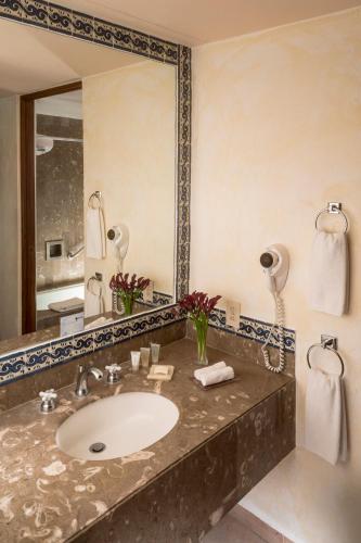 a bathroom with a sink and a large mirror at Fiesta Americana Hacienda Galindo Resort & Spa in Galindo