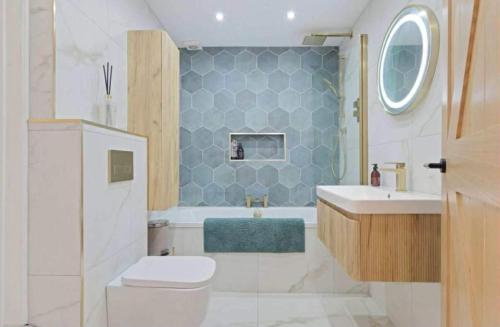 a bathroom with a toilet and a tub and a sink at Cedar Barn Getaway 3 Bed Sleeps 6 Parking in Bromsgrove