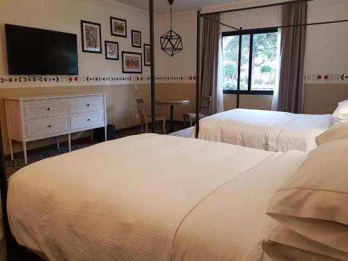 a hotel room with two beds and a flat screen tv at Fiesta Americana Hacienda Galindo Resort & Spa in Galindo