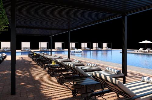 a row of lounge chairs in a swimming pool at Fiesta Americana Hacienda Galindo Resort & Spa in Galindo