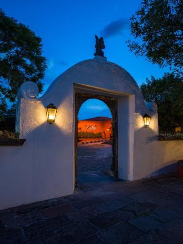 a building with an arch with a sunset in the background at Fiesta Americana Hacienda Galindo Resort & Spa in Galindo