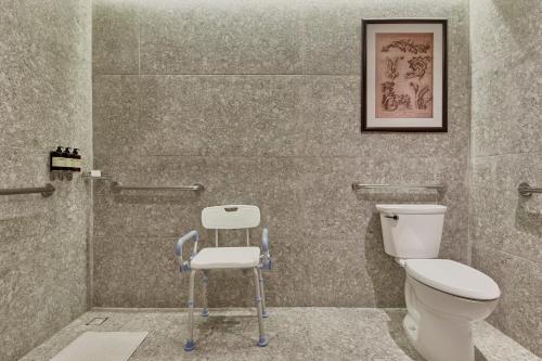 a bathroom with a toilet and a chair in it at Fiesta Americana Hacienda Galindo Resort & Spa in Galindo
